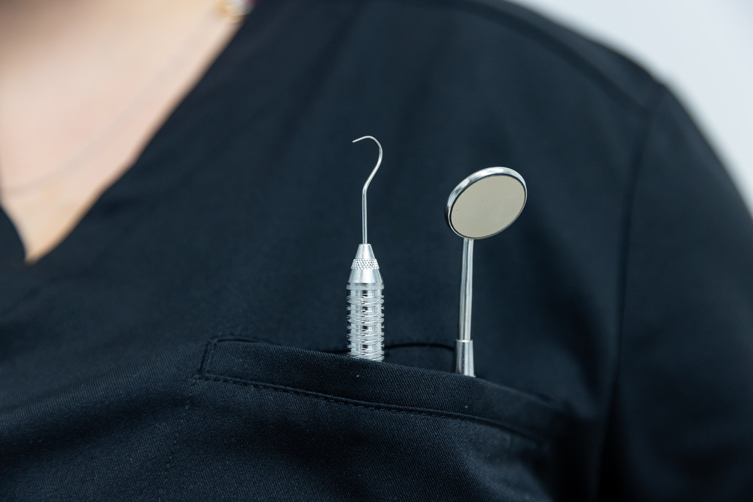 Mirror and probe in the pocket of one of the clinic's dentists