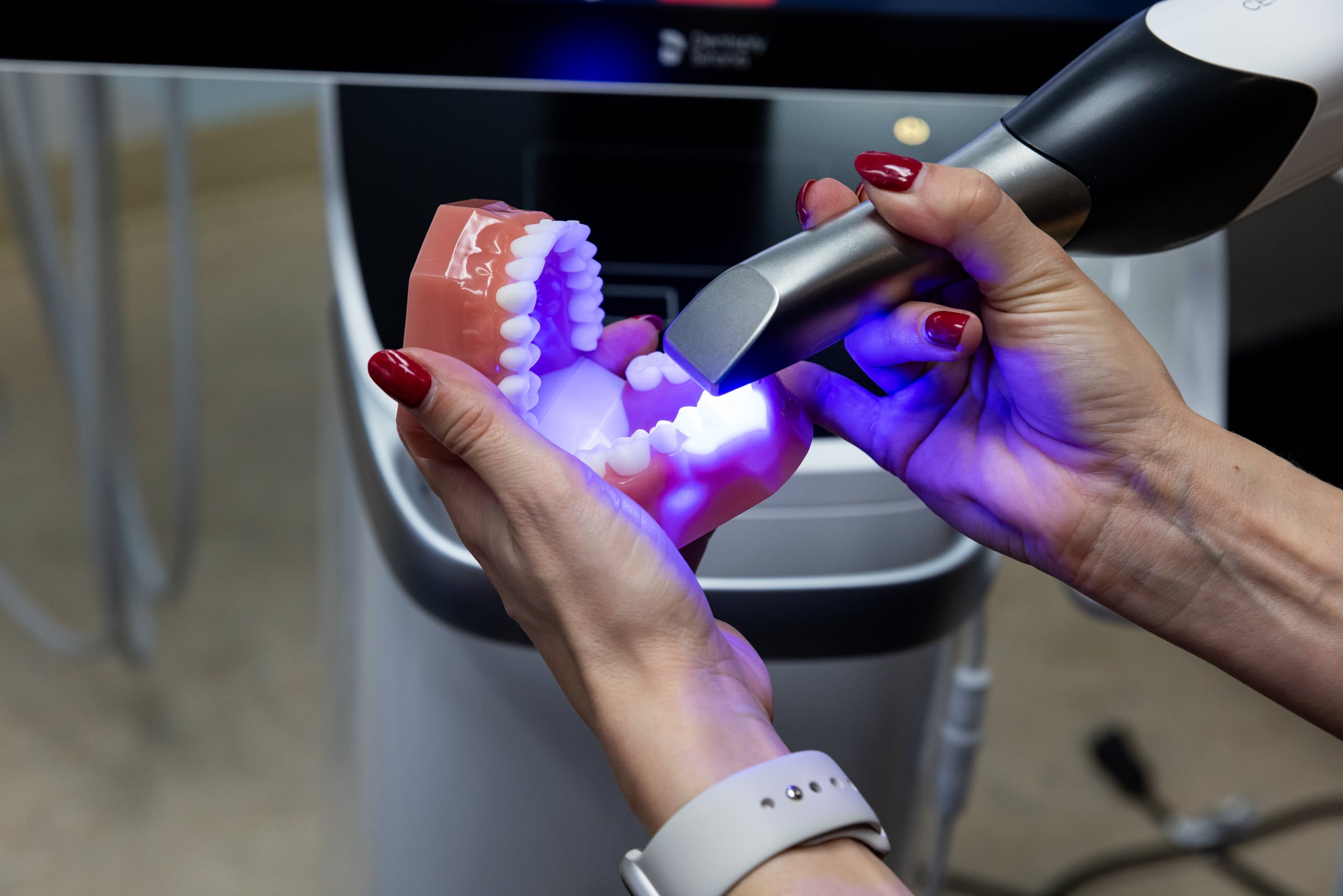 The intraoral scanner passed over a model, with the digital impression on screen
